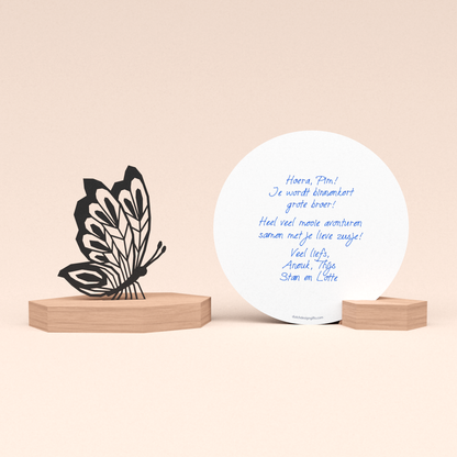 luxe zwangerschapscadeau kaarthouder met vlinder illustratie en ronde kaart met door schrijf-robot geschreven persoonlijke felicitatie