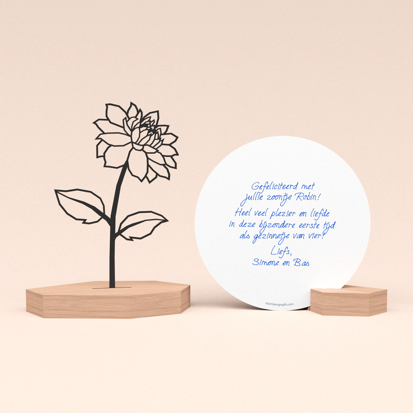 luxe geboortecadeau met bloem illustratie in houten standaard en door schrijfrobot met pen geschreven ronde wenskaart in houten blokje