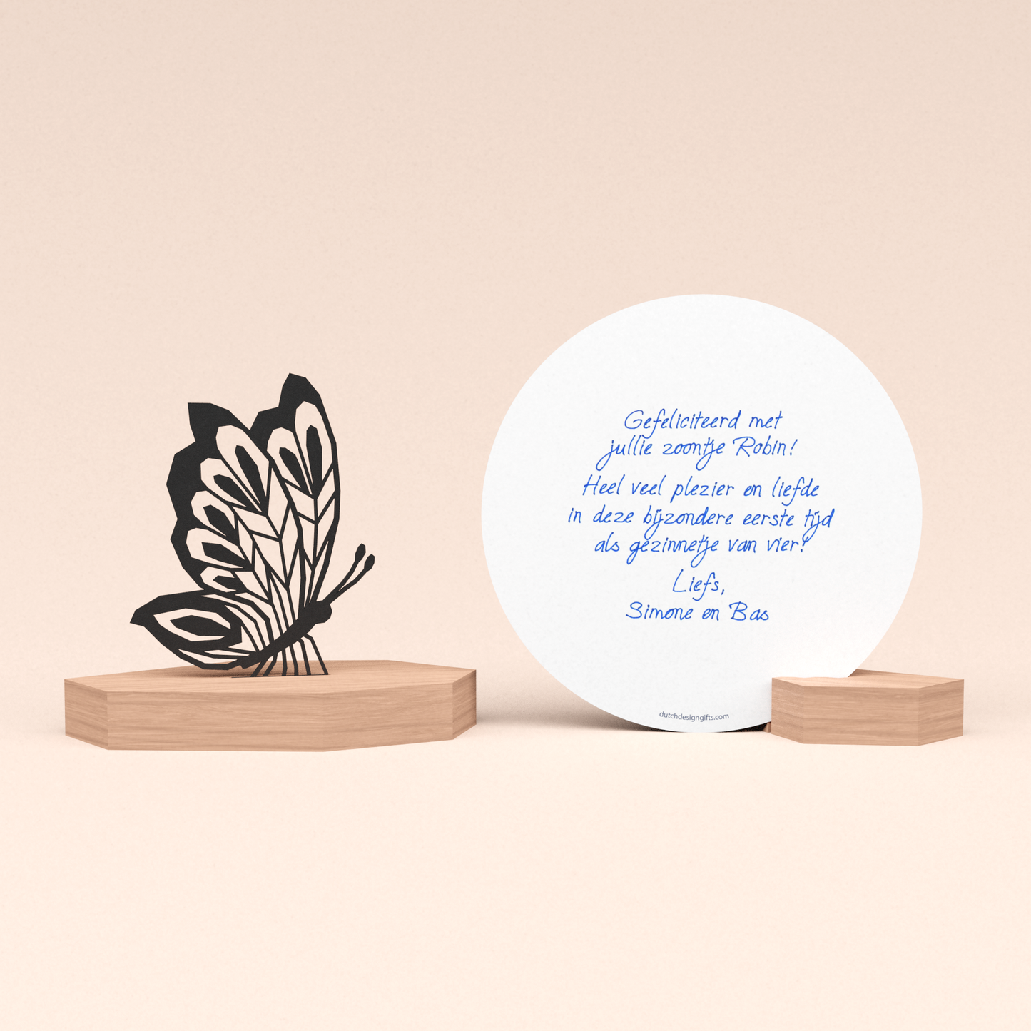luxe geboortecadeau met vlinder illustratie in houten standaard en ronde wenskaart met door schrijf-robot geschreven geboorte felicitatie