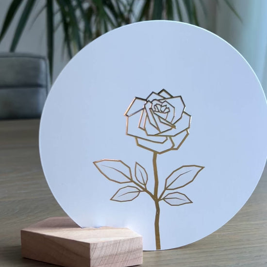 Witte ronde wenskaart in een houten houdertje met een gouden abstracte roos