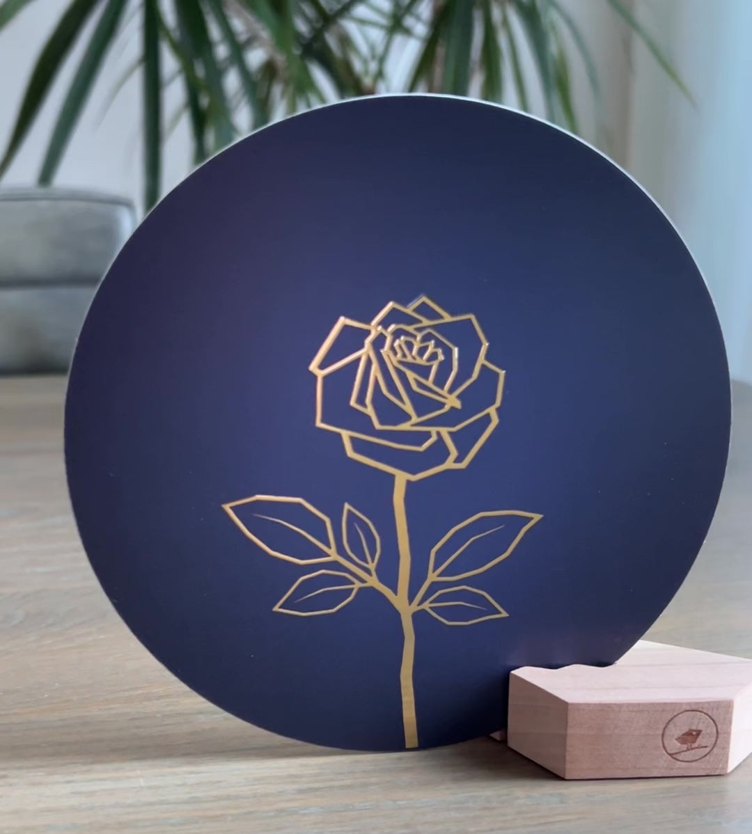 Donkerblauwe ronde wenskaart in een houten blokje met een gouden abstracte roos